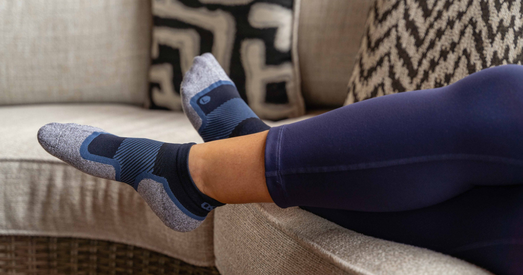 Person relaxing while wearing the OrthoSleeve Wellness Care Socks