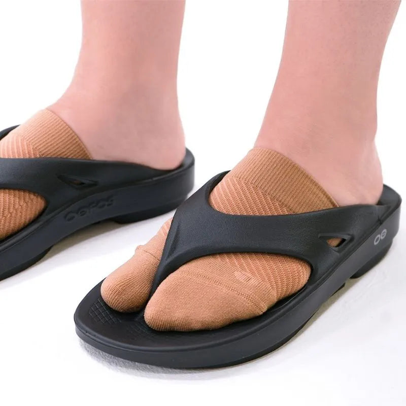 Up close image of someone wearing the OrthoSleeve Forefoot Compression Sleeves while wearing flip flops