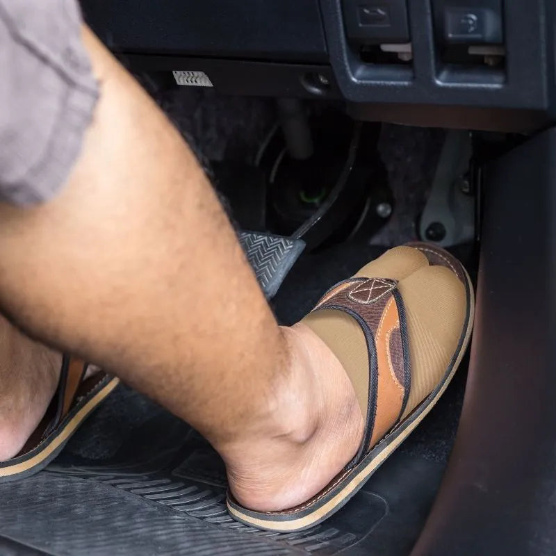 Man wearing the OrthoSleeve Forefoot Compression Sleeves with flip flops while driving