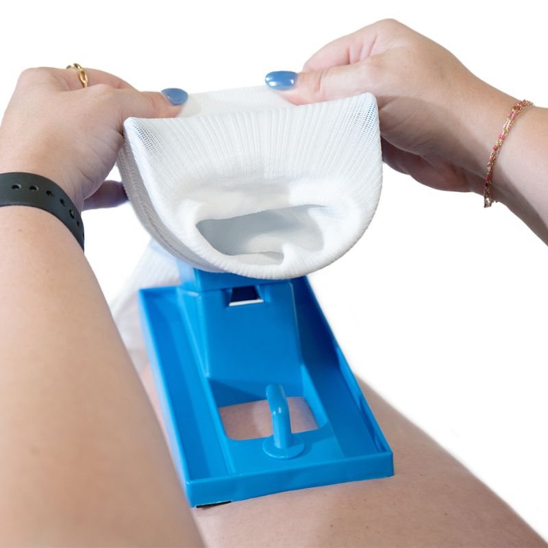 Person putting a sock on the cradle base of the sock aid device