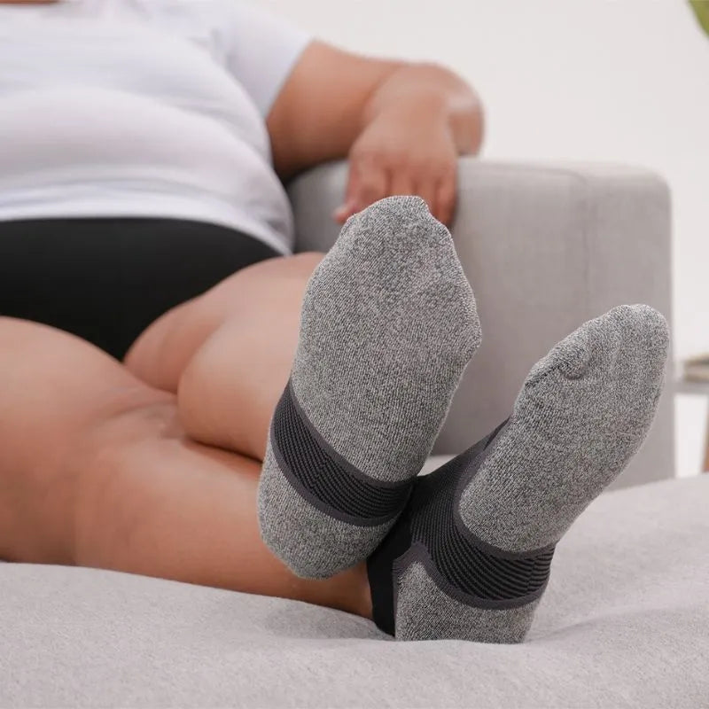 Lifestyle image of someone wearing the OrthoSleeve Wide Wellness Care Socks while relaxing on the couch